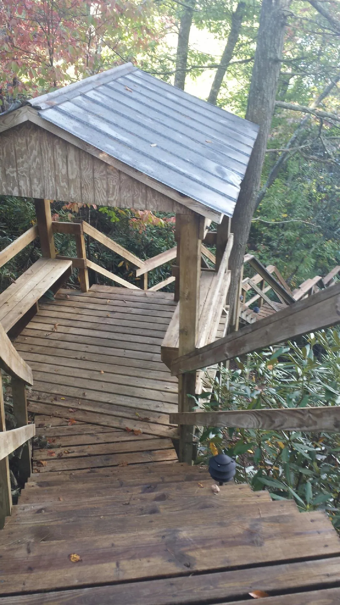 Metal roofed shelter over wooden steps on a wooded walkway — Skylight Repair & Installation work by our crew in Ronkonkoma