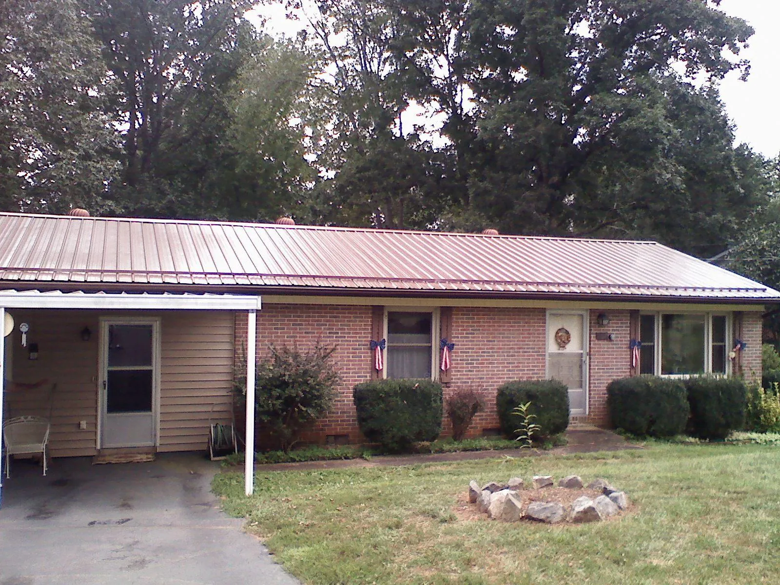 Bronze metal roof and carport on a brick ranch home — Roof Repair work by our crew in Ronkonkoma